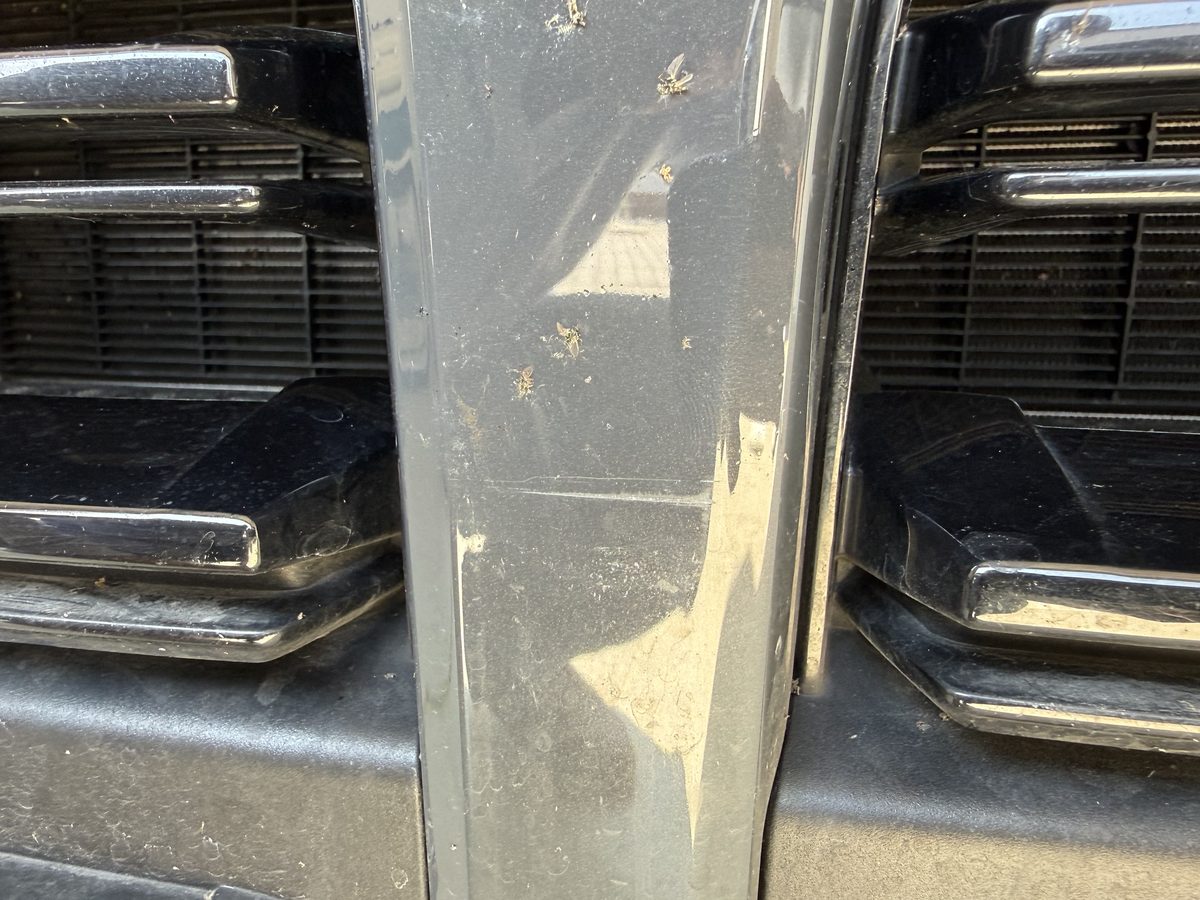 Schramme über der Chromleiste am Kühlergrill eines dunkelgrauen BMW 3er, Schadenhöhe 2.668,45 €